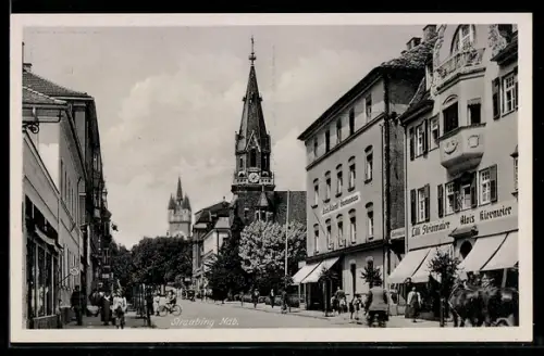 AK Straubing /Ndb., Strassenpartie mit Geschäften und Kirche