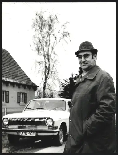 Fotografie Mann steht neben Auto GAZ-24 auf einer Strasse, Grossformat 25 x 19cm