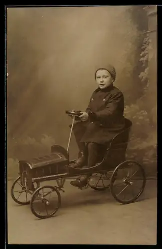 Foto-AK Junge sitzt in einem Spielzeugauto