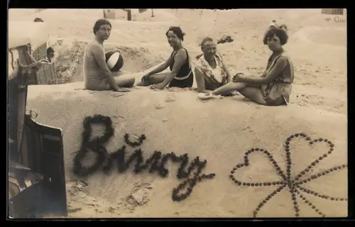 Foto-AK Vier Frauen sitzen auf einer Sandplastik mit Kleeblatt