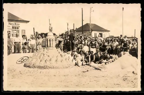 Foto-AK Gesellschaft am Strand mit eindrucksvoller Sandplastik