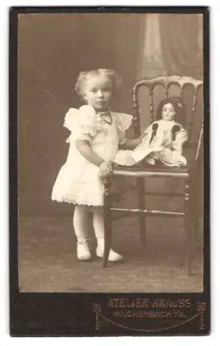 Fotografie Atelier Krauss, Hilchenbach i. W., Kind mit Puppe auf einem Stuhl