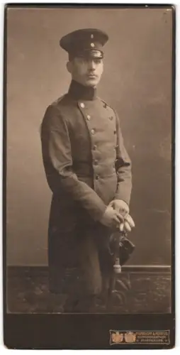 Fotografie Pieperhoff & Fendius, Magdeburg, Alte Ulrichsstr. 14, Leutnant im Überrock mit Schirmmütze und Säbel