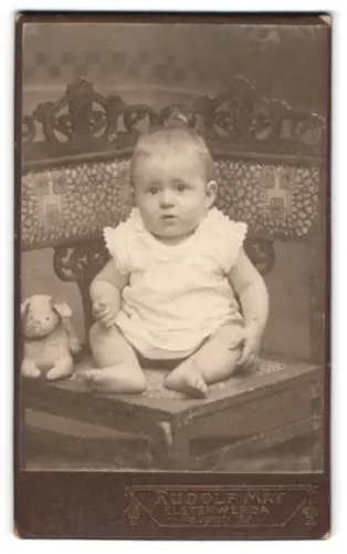 Fotografie Rudolf May, Elsterwerda, Hauptstrasse 22, Kleinkind auf kunstvollem Stuhl
