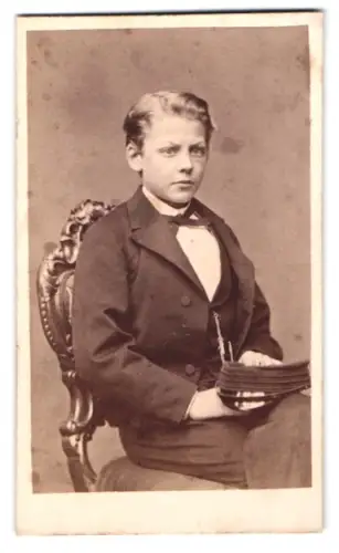 Fotografie August Roesler, Stockholm, Drottninggatan 23, Junge in eleganter Kleidung auf einem Stuhl
