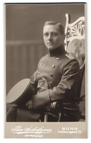 Fotografie Theo Schafgans, Bonn, Rathausgasse 14, Leutnant vom Regiment Nr. 166 im Überrock mit Schirmmütze und Säbel