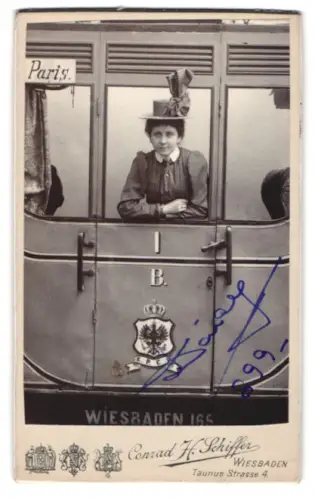 Fotografie Conrad H. Schiffer, Wiesbaden, Taunusstrasse 4, Dame am Fenster eines Zugabteils, Studiokulisse