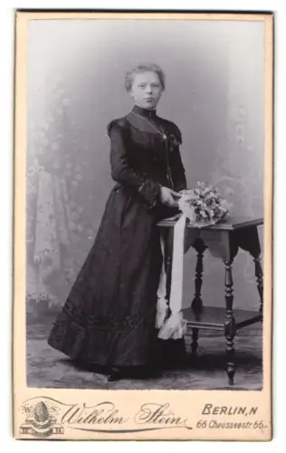 Fotografie Wilhelm Stein, Berlin, Chausseestr. 66, Dame in elegantem Kleid mit Blumenstrauss