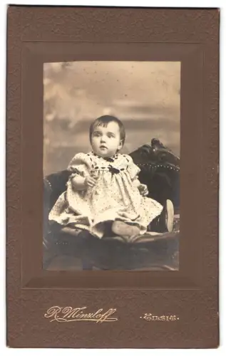 Fotografie R. Minzloff, Tilsit, Kleinkind auf Sessel