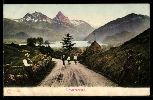 AK Lauerz, Lowerzersee, Landstrasse mit Heuhaufen und Bergkulisse