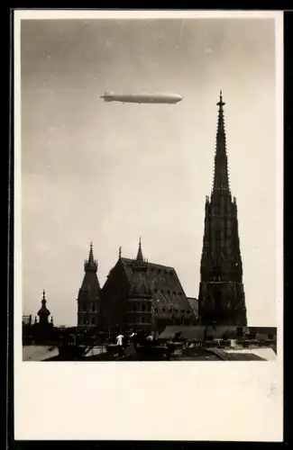 Foto-AK Wien, Zeppelin-Luftschiff im Fluge über der Stephanskirche