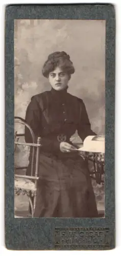 Fotografie F. W. Cisar, Haag, Minna am Tisch sitzend
