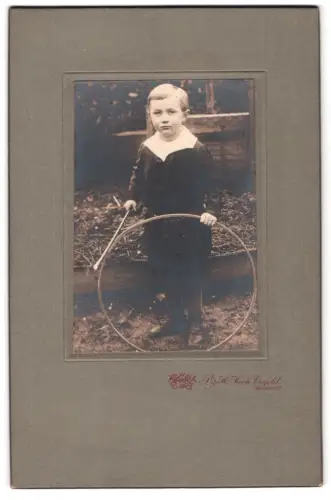 Fotografie P. & H. Koch, Krefeld, Rheinstr. 32, Portrait des Jungen Hermann Mayer mit Reifen, 1919