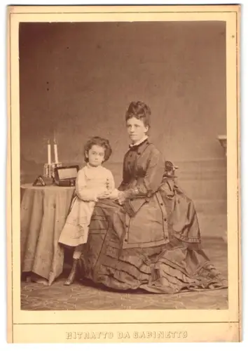 Fotografie J. B. Rottmayer & Comp., Trieste, Via s.s. Martiri 1, Porträt der Frau Mirella Klundr mit Kind neben Tisch