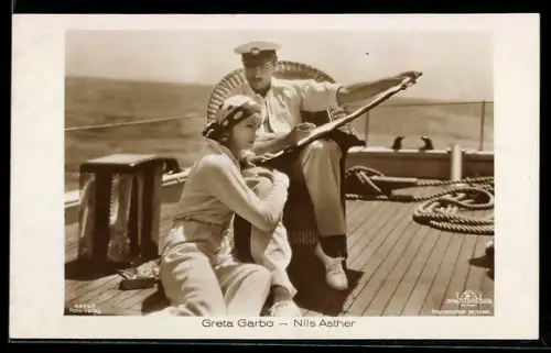 AK Schauspieler Greta Garbo mit gepunktetem Kopftuch und Nils Asther mit Kapitänsmütze