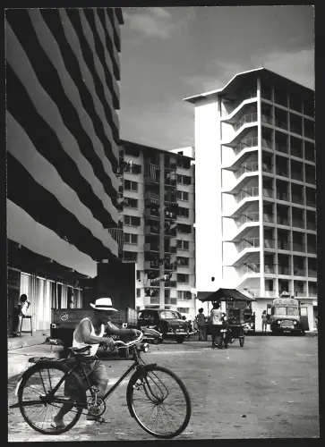 Fotografie Ansicht Katong /Singapur, Strassenpartie mit Hochhäusern und rauchendem Radfahrer