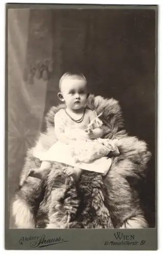 Fotografie Atelier Strauss, Wien, Mariahilferstr. 81, Porträt eines kleinen Kindes auf einem Pelz