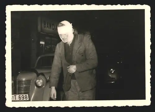 Fotografie Auto Opel, Mann stark bandagiert nebst PKW
