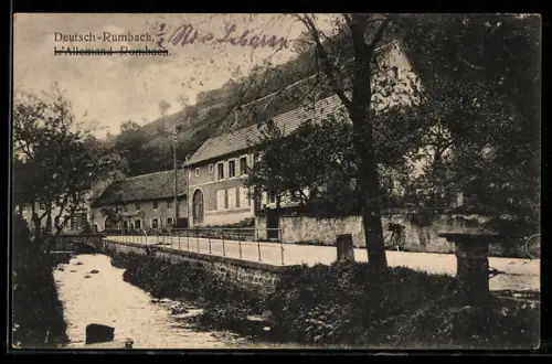 AK Deutsch-Rumbach, Häuser an der Bachuferstrasse mit Brücke