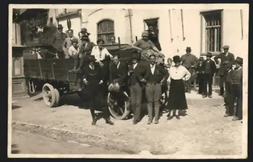 Fotografie Lastwagen, LKW-Pritsche mit Vollgummireifen & Ortsgemeinschaft in Sonntagsbekleidung