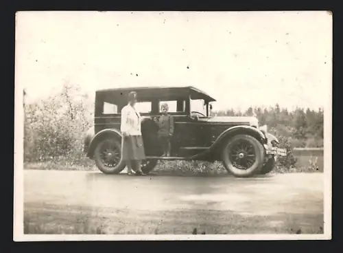 Fotografie Auto, Mutter nebst Sohn auf PKW-Trittbrett stehend