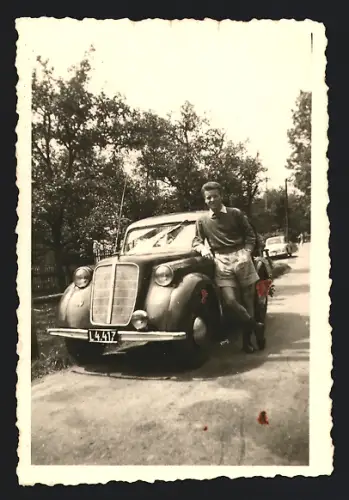 Fotografie Auto Opel, Bursche lehnt am PKW mit Kennzeichen Österreich