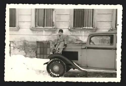 Fotografie Auto, Knabe auf PKW Kotflügel stehend