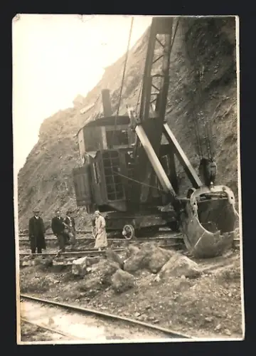 Fotografie Baumaschine Löffelbagger mit Seilzug auf Eisenbahngleisen fahrend