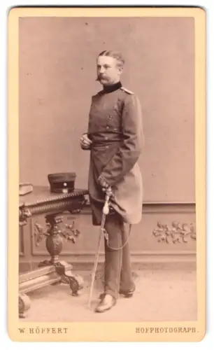 Fotografie H. Höffert, Dresden, See-Str. 10, Offizier Claessen im Überrock mit Schirmmütze und Säbel