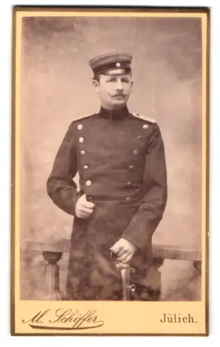 Fotografie M. Schiffer, Jülich, Grosse Roer Strasse 29a, Offizier Rudolph im Überrock mit Schirmmütze und Säbel