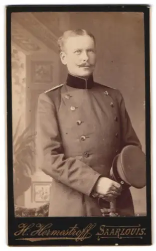 Fotografie H. Hermestroff, Saarlouis, Silberherzstrasse 11, Offizier Mottau im Überrock mit Schirmmütze und Säbel