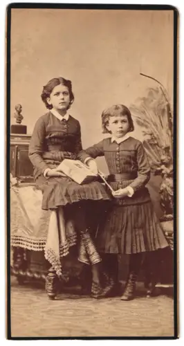 Fotografie unbekannter Fotograf und Ort, Zwei Mädchen mit Fotoalbum im Atelier
