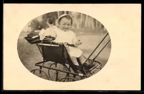 Foto-AK Kleinkind mit Ball in einem Kinderwagen