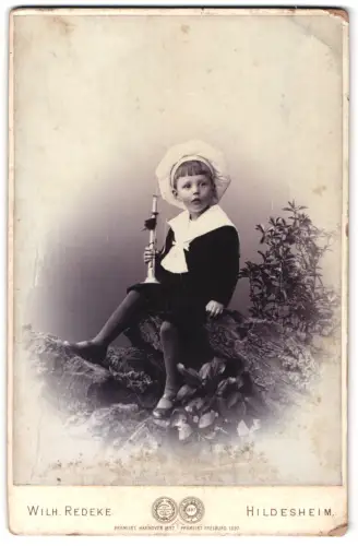 Fotografie Wilh. Redeke, Hildesheim, Kreuzstrasse 22, Kind mit Kerze auf Baumstamm