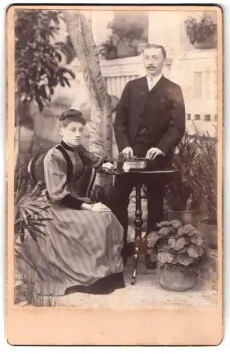 Fotografie unbekannter Fotograf und Ort, Paar mit Pflanzenarrangement