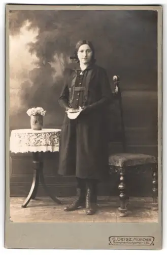 Fotografie G. Deisz, München, Nymphenburgerstr. 150, Stehende Dame mit Buch und Spitzen-Tischdecke im April 1919
