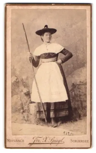 Fotografie Frz. Xaver Spiegel, Miesbach, Dame in Tracht mit Holzstock