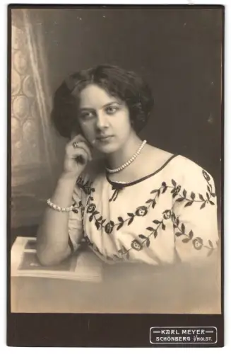 Fotografie Karl Meyer, Schönberg i. Holstein, Frau im bestickten Kleid mit Perlenkette