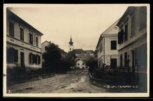 AK Gaspoltshofen /Ob.Ö., Strassenpartie mit Wohnhäusern und Blick auf die Kirche