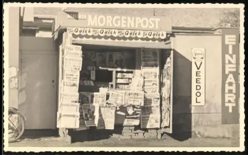 Fotografie unbekannter Fotograf, Ansicht Berlin, Kiosk mit Reklame Berliner Morgenpost, Veedol, Quick, Bravo u.a.