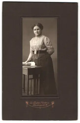 Fotografie W. Glahn, Nürnberg, Allersbergerstr. 51, Frau an einem Tisch