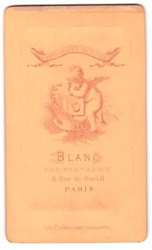 Fotografie Blanc, Paris, Rue de Buci 11, Kleines Engelchen lehnt über einer Kamera und Malerpalette