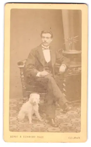 Fotografie Gerst & Schmidt, Colmar, Rue des Clés 18, Eleganter Herr mit weissem Hund im Atelier