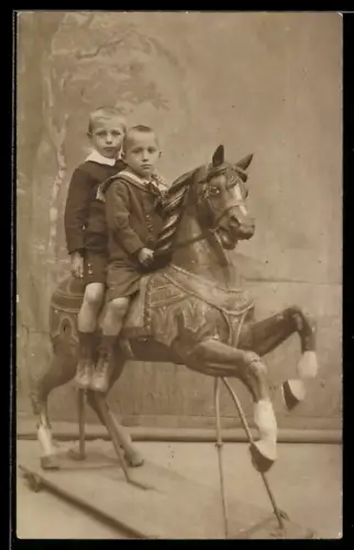 Foto-AK Zwei Jungen auf einem Spielzeug-Pferd