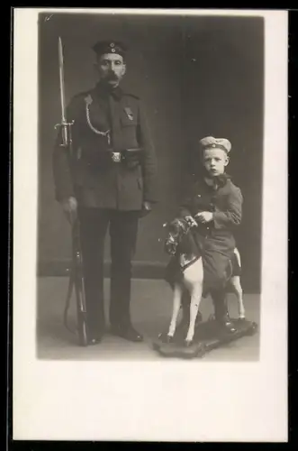 Foto-AK Soldat in Uniform, Junge in Uniform auf Spielzeugpferd