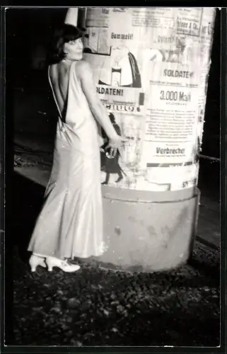 Fotografie Hübsche Dame im Abendkleid vor Litfasssäule posierend