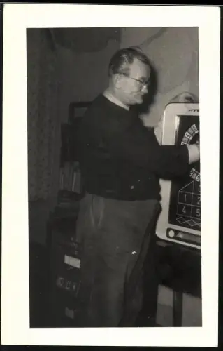 Fotografie Herr bedient Spielautomat im Wohnzimmer
