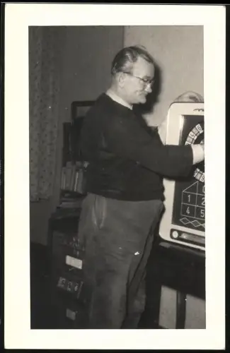 Fotografie Herr bedient Spielautomat im Wohnzimmer