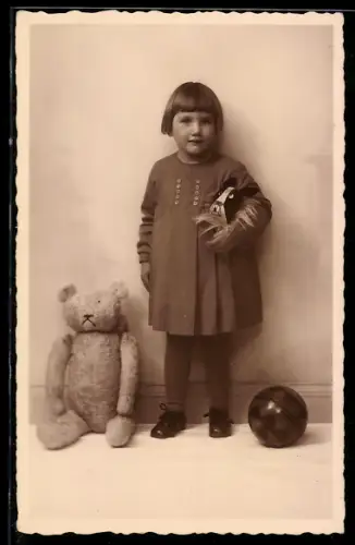 Foto-AK Mädchen steht neben ihrem sitzenden Teddy