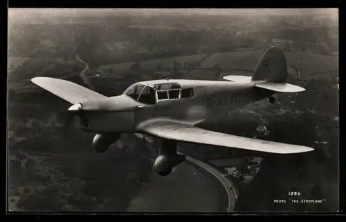 AK Britisches Tiefdecker-Flugzeug mit Kennung G-AEYC im Fluge über Eisenbahnstrecke